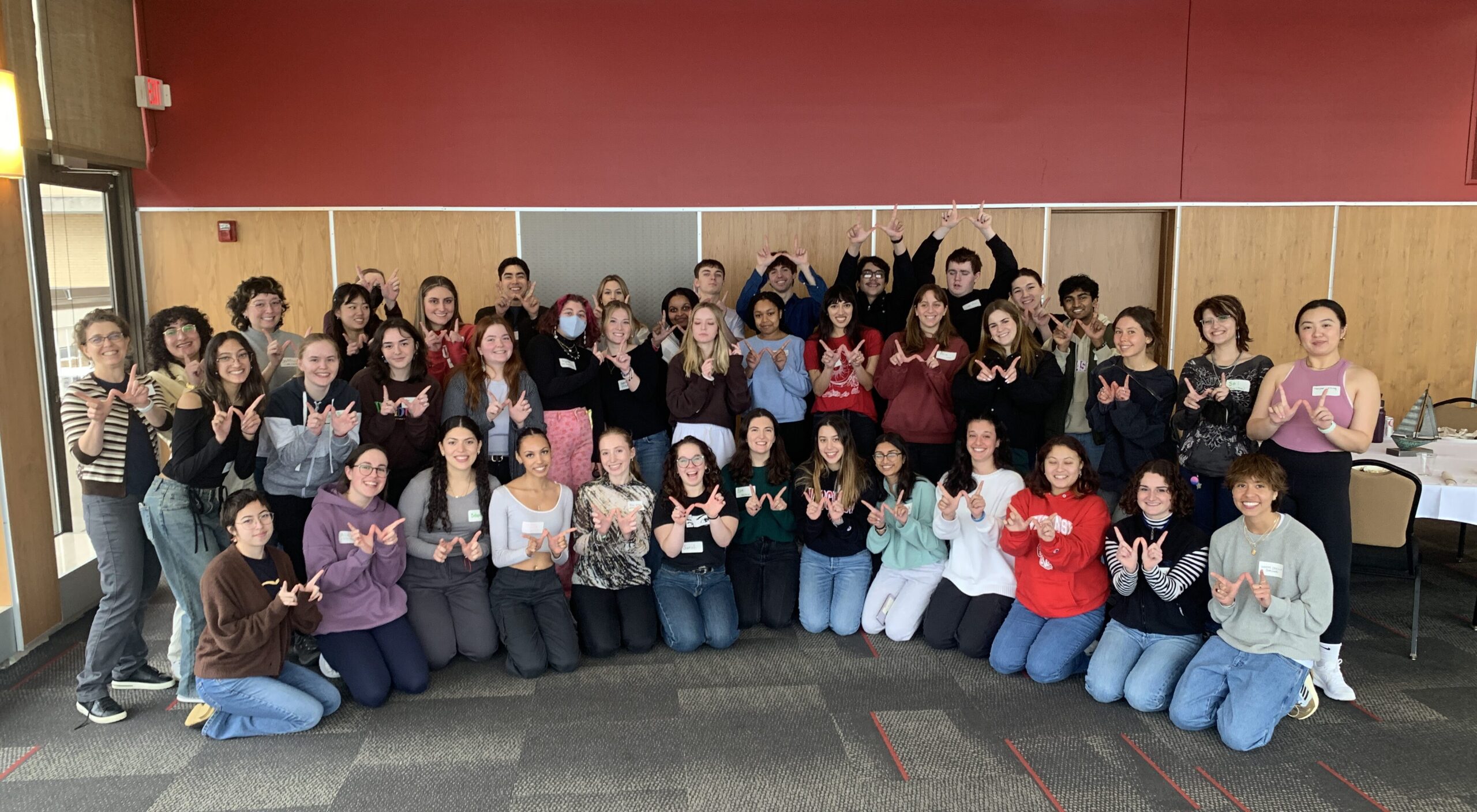 An image of forty students in the Wisconsin International Scholars Program smiling and showing the Wisconsin W symbol with their hands